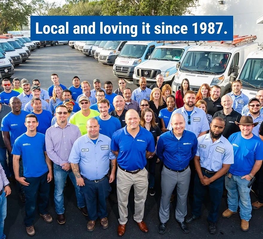 The Advantage Heating & Air Conditioning crew gathered in front of the company service vans — local Oklahoma City team since 1987.